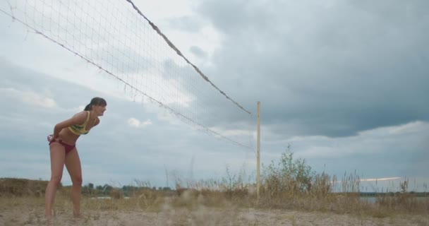 Jeunes belles femmes jouent au beach-volley dans un paysage pittoresque avec ciel nuageux, entraînement et compétition — Video