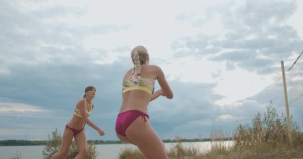 Les joueuses professionnelles de beach-volley s'entraînent sur un terrain de sable en été, passant et attaquant une autre équipe — Video