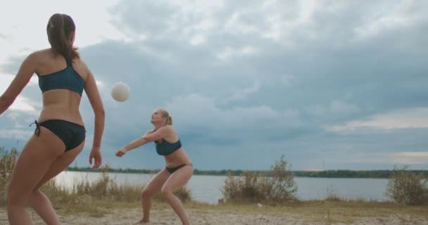 Les joueuses de beach-volley passent le ballon et attaquent, match amical de deux équipes féminines le jour de l'été — Video