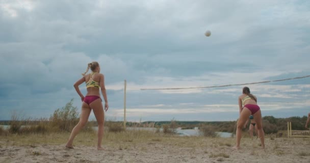Kvinna spelare i beach volleyboll serverar boll, slow-motion skott av passerar och attackerar, match mellan två damer lag — Stockvideo