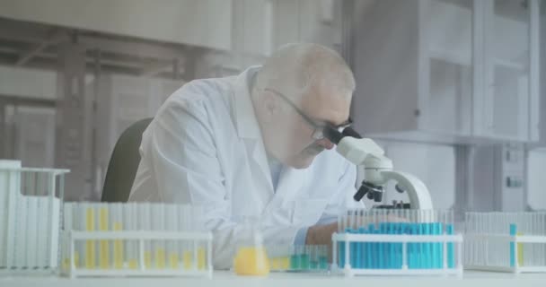 Homme barbu chercheur caucasien portant des lunettes de protection et de travailler avec un spbas microscope. scientifique utilisant le microscope dans un laboratoire. Rechercher le vaccin contre le coronavirus — Video