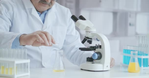Wissenschaftler testen auf Covid-19 oder Corona-Virus, indem sie wissenschaftliche Röhrchen zur Erforschung und Behandlung von Krankheiten in einem Labor oder Krankenhaus verwenden. Medizinische Behandlungskonzepte — Stockvideo