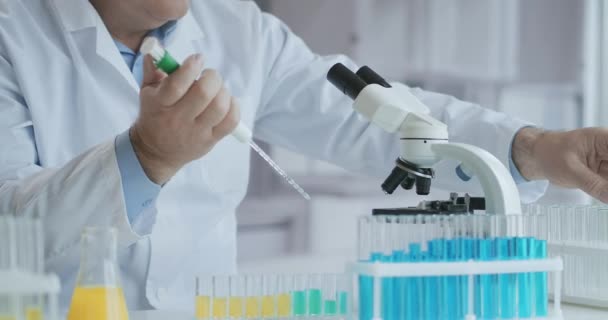 男性医師は研究室でワクチンを開発しています。コロナウイルス, COVID-19, 2019-ncov医薬品研究コンセプト.顕微鏡の使用 — ストック動画