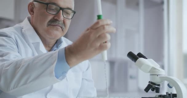 Ο αρσενικός γιατρός εργάζεται στο εργαστήριο, αναπτύσσοντας ένα εμβόλιο. Coronavirus, COVID-19, 2019-ncov medicines research concept. Χρήση μικροσκοπίου — Αρχείο Βίντεο