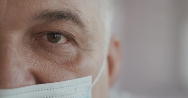 Médecin ou infirmière en uniforme, masque regardant droit devant la caméra. Gros plan sur les yeux. au ralenti — Video