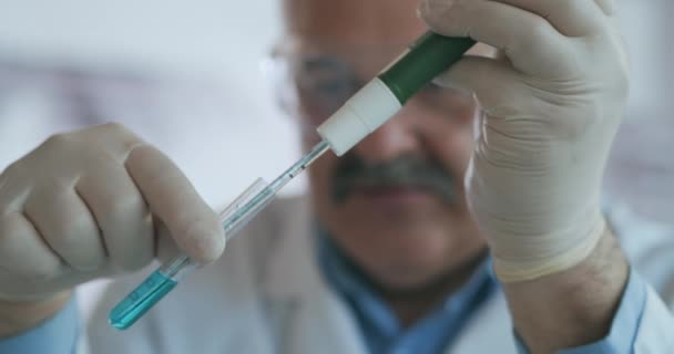 Technik opatrně odkapává roztok z pipety do skleněných zkumavek pro analýzu DNA. Doctor Drips Blue Solution Into Glass Tube, Coronavirus Pandemic, Hands Closeup. — Stock video