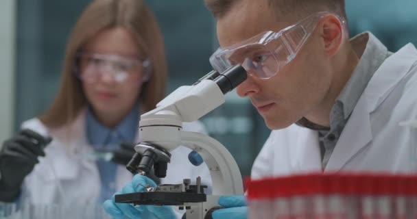 Coronavirus vakcina laboratóriumi kutatása és fejlesztése, kovid-19 világjárvány és gyógyszeripar, virológusok párja — Stock videók