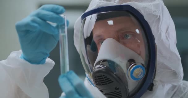 Virolojist, laboratuvarda insan yüzünün yakın plan görüntüsü olan Coperid-19 'dan alınan aşıyı elinde tutuyor. — Stok video
