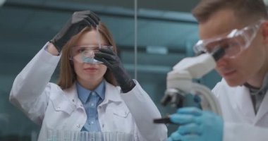 İlaç şirketinin laboratuarında, insanlar yeni aşı ve ilaç üzerinde çalışıyorlar, erkek ve kadın araştırıyorlar.