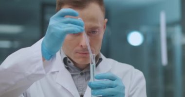 Endüstriyel fabrikadaki kimya laboratuvarında kalite kontrol bölümü, kadın ve erkek ürünlerin örneklerini araştırıyor.