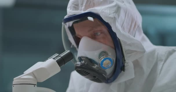 Ο άνθρωπος χρησιμοποιεί σύγχρονο ηλεκτρονικό μικροσκόπιο για την εξερεύνηση βακτηρίων και ιών στο εργαστήριο, προστατεύοντας τον εαυτό του με μάσκα με αναπνευστήρα — Αρχείο Βίντεο