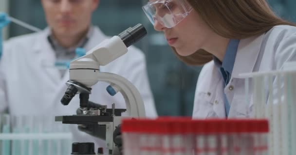 Grupo de profesionales de la salud que trabajan en el desarrollo de la curación y la vacuna del coronavirus en el laboratorio médico — Vídeo de stock