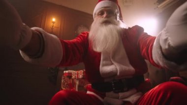 Noel Baba evinde çalışıyor, Noel için iyi çocuklara hediyeler hazırlıyor, sakallı yaşlı bir adamın yavaş çekimde portresi.