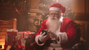 Yaşlı Noel Baba akıllı telefonuyla mesaj yazıyor. Noel 'de odasında tek başına oturuyor. Sihirbaz da cihaz kullanıyor.