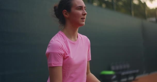 Une joueuse de tennis sur le terrain au coucher du soleil après un match fatiguée impatiente et concentrée après un match difficile — Video