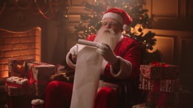 Noel Baba iyi çocukların listesini okuyor ve Noel için hediyeleri kontrol ediyor. Noel akşamı süslü odasında oturuyor.