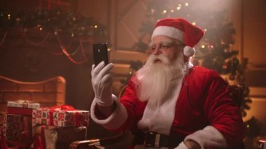 Yaşlı Noel Baba internet üzerinden modern iletişimi kullanıyor. Noel tatillerinde akıllı telefondan arıyor.