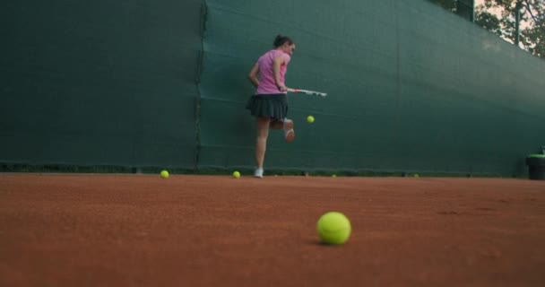 Närbild bilder av kvinnliga ben i sportskor och protes på hennes ben plocka upp tennisbollar från tennisbanan marken — Stockvideo