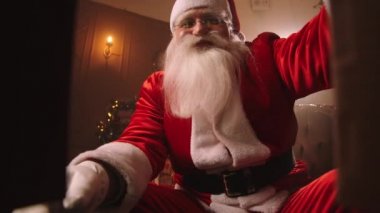  Noel Baba hediye kutusunu açıyor ve kamerayı alıyor, onunla konuşuyor, yaşlı büyücünün Noel gecesi gülümseyen yüzü.