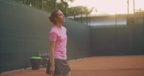 Concentração antes do último serviço decisivo. Uma mulher num campo de ténis em câmara lenta e luz solar — Vídeo de Stock