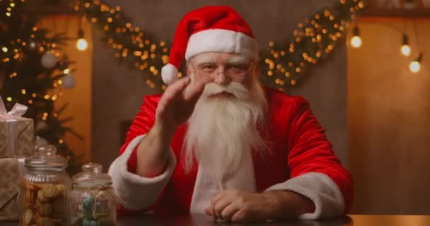 Headshot Kijken naar de camera Gelukkig oud bebaarde Kerstman in kostuum en zwaaiende hand video bellen in zoom, opname video Vrolijk kerstgroet, gezicht camera bekijken. — Stockvideo