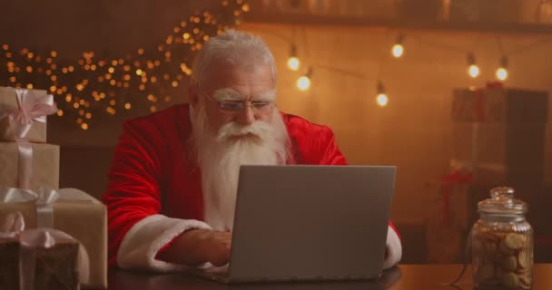 Neşeli Noel Baba dizüstü bilgisayarda çalışıyor. Noel Baba dizüstü bilgisayar kullanıyor, yakın plan.. — Stok video