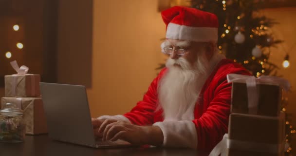 Веселый Санта работает на ноутбуке. Санта-Клаус с помощью ноутбука крупным планом. — стоковое видео