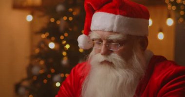 Neşeli Noel Baba dizüstü bilgisayarda çalışıyor. Noel Baba dizüstü bilgisayar kullanıyor, yakın plan..