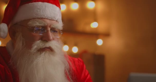 Jolly Santa trabajando en una computadora portátil. Cláusula de Santa utilizando el ordenador portátil, primer plano. — Vídeo de stock