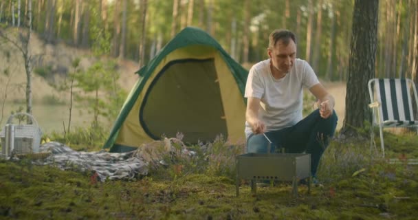 Turista él erdei tábor egyedül, gyulladó szén chargrill főzés vacsora, kirándulás az erdőben a nyári vakáció — Stock videók