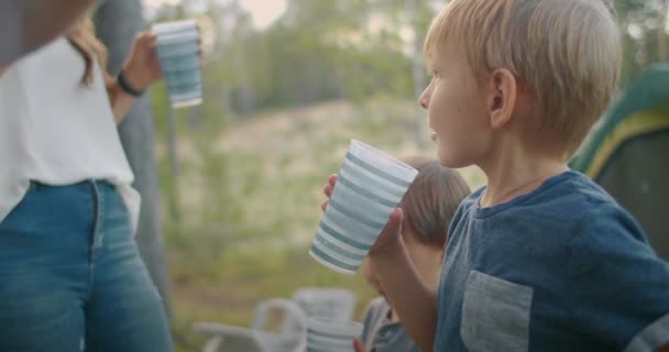 Familjen vilar på naturen, camping i skogen med tält, små pojkar dricker vatten, sommarsemester — Stockvideo