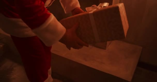W świąteczną noc Mikołaj dostarcza prezenty do domów, kiedy wszyscy śpią. Mikołaj zostawi prezenty pod choinką w urządzonym domu — Wideo stockowe
