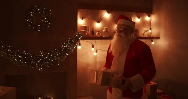 Le soir de Noël, le Père Noël offre des cadeaux aux maisons pendant que tout le monde dort. Père Noël laissera des cadeaux sous le sapin de Noël dans la maison décorée — Video