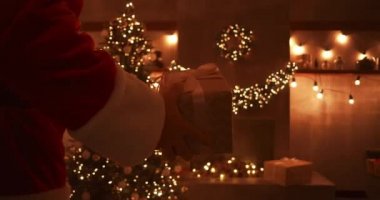 Noel Baba 'nın elinin yakın çekimi çocuklar için Noel ağacının altına hediyeler getirir. Noel gecesi çocuklara hediyeler ver. Noel Baba Noel ağacının altına hediye koyar.