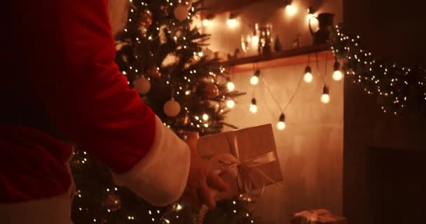 En la noche de Navidad, Santa entrega regalos a los hogares mientras todos duermen. Santa dejará regalos bajo el árbol de Navidad en la casa decorada — Vídeos de Stock