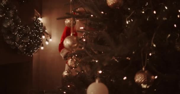 Le Père Noël apporte des cadeaux sous le sapin de Noël pour les enfants. Offrez des cadeaux aux enfants le soir de Noël. Père Noël met un cadeau sous le sapin de Noël — Video