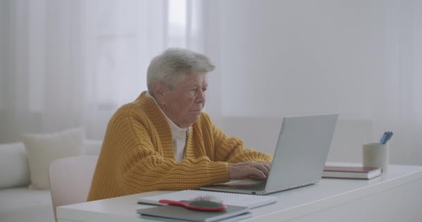 年长的老年妇女在键盘上打字，在膝上型计算机上在线网络研讨会，在家远程工作或社交远程学习。60-80岁女商人 — 图库视频影像