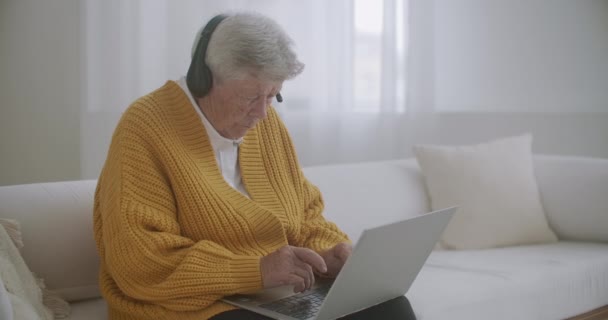 Idősebb idősebb nő, aki üzenetet gépel a billentyűzeten, online webinárium laptopon távmunka vagy közösségi távtanulás otthonról. 60-80-as évek üzletasszonya — Stock videók