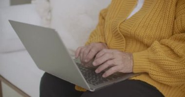 Neşeli beyaz kadın bir projeyi bitiriyor. Bilgisayarında çalışan mutlu olgun bir kadın, kendini izole ederken onu evde bitiriyor..