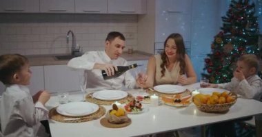 Farklı kuşaklardan gelen mutlu Kafkas ailesi Noel 'i evde kutluyor. İnsanlar yemek yiyor, konuşuyor ve gülümsüyor.