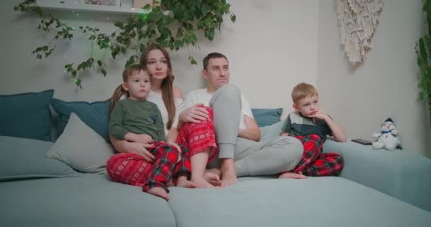 Familia de tres - padre, madre e hijo de remolque viendo la televisión por la noche. Juntos, cuarentena, quedaos en casa — Vídeos de Stock