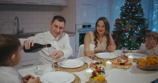 Glückliche große kaukasische Familie verschiedener Generationen, die zu Hause Weihnachten feiert. Menschen, die ein Abendessen Weihnachtsfeier essen, reden und lächeln — Stockvideo