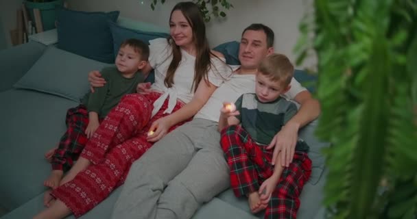 Familia de tres - padre, madre e hijo de remolque viendo la televisión por la noche. Juntos, cuarentena, quedaos en casa — Vídeos de Stock