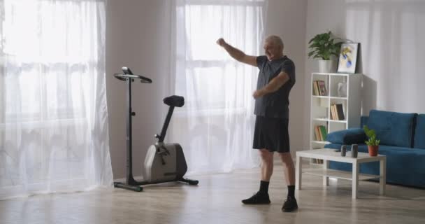 Утренняя гимнастика мужчины среднего возраста, забота о здоровье, обучение в одиночку в гостиной — стоковое видео