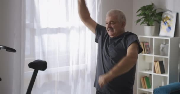 Hombre adulto con bigote está haciendo gimnasia en casa por la mañana, estilo de vida saludable para las personas mayores — Vídeos de Stock