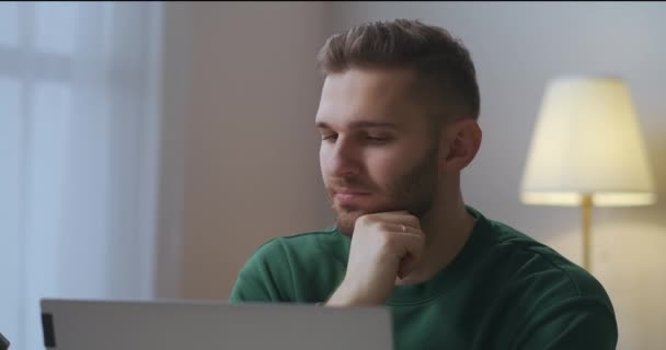 Düşünceli adam dizüstü bilgisayarın önünde oturuyor, yazar ya da gazeteci olarak çalışıyor, akşamları evde yazıyor. — Stok video