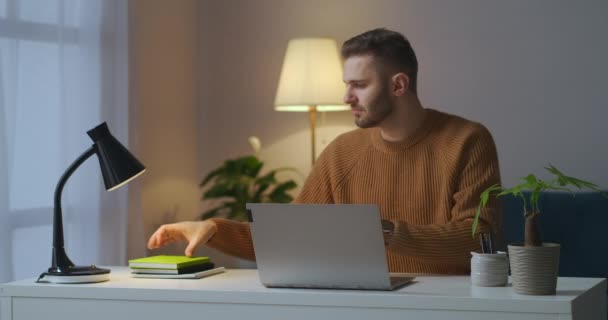 年轻的男生正在网上学习，使用带有互联网连接的笔记本电脑，在笔记本中输入密码 — 图库视频影像