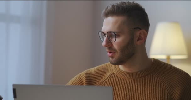 Männlicher Benutzer schließt Laptop und setzt Brille nach dem Arbeitstag zu Hause ab, mittleres Porträt eines erschöpften Mannes — Stockvideo