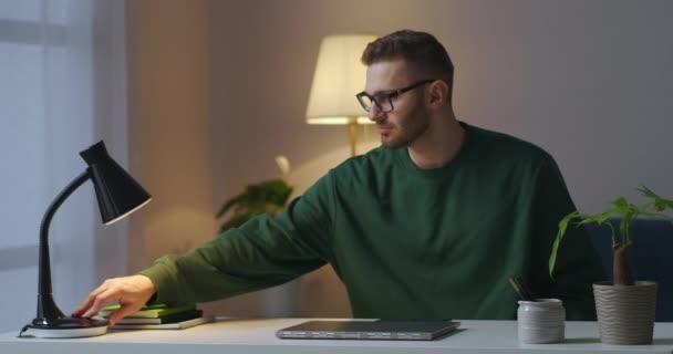 Muž pracuje na dálku v domácí kanceláři, otevírá notebook a posílá e-maily, na volné noze a samostatně výdělečně činné — Stock video