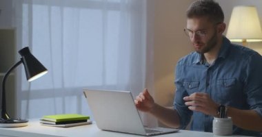 Uzak iletişim ve internet pazarlığı, erkek uzman el hareketleriyle web kamerasına bakarak konuşuyor.